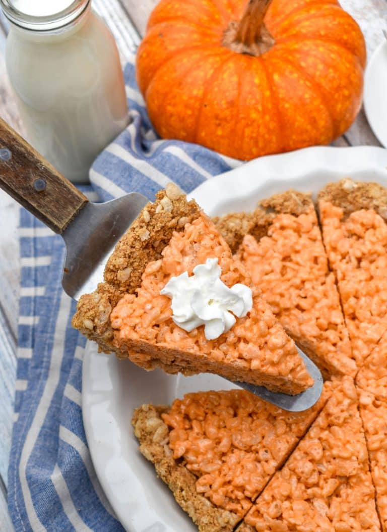 a wooden handled pie server holding up a slice of pumpkin pie rice krispie treat