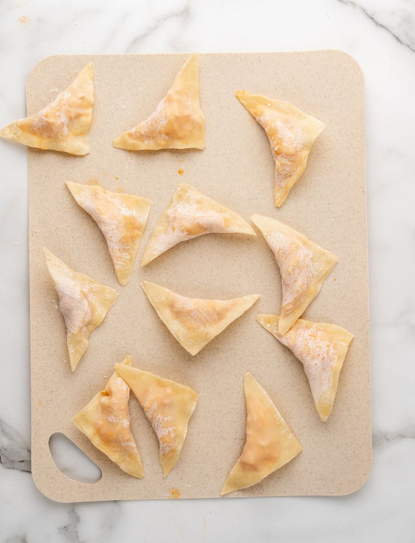 filled and folded homemade buffalo blasts on a plastic cutting board