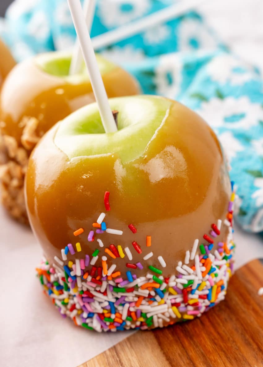 homemade caramel apples on a wooden cutting board