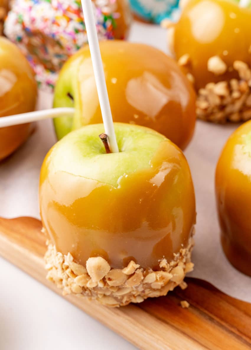 homemade caramel apples on a wooden cutting board