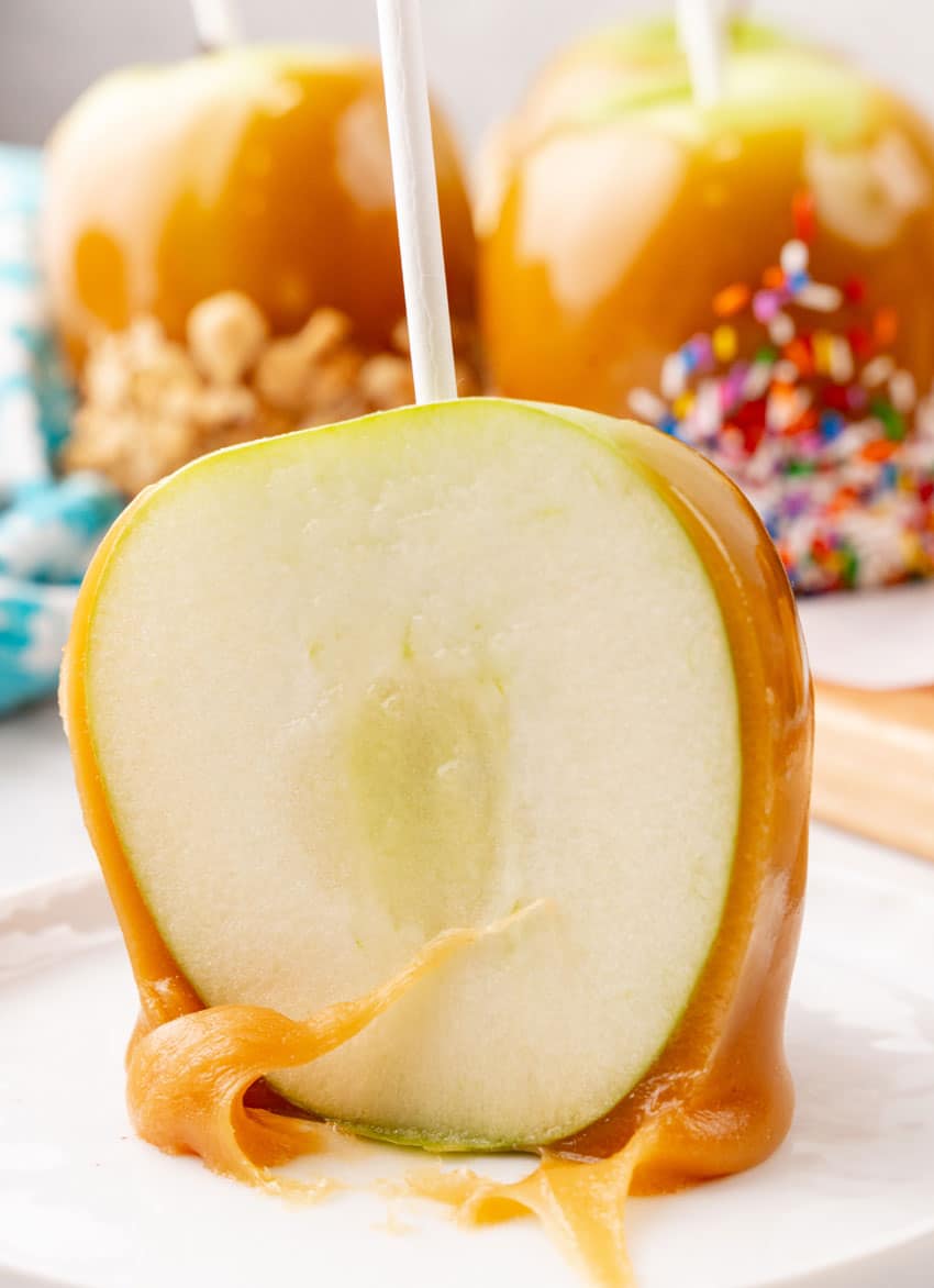 a cut caramel apple half on a small white dessert plate