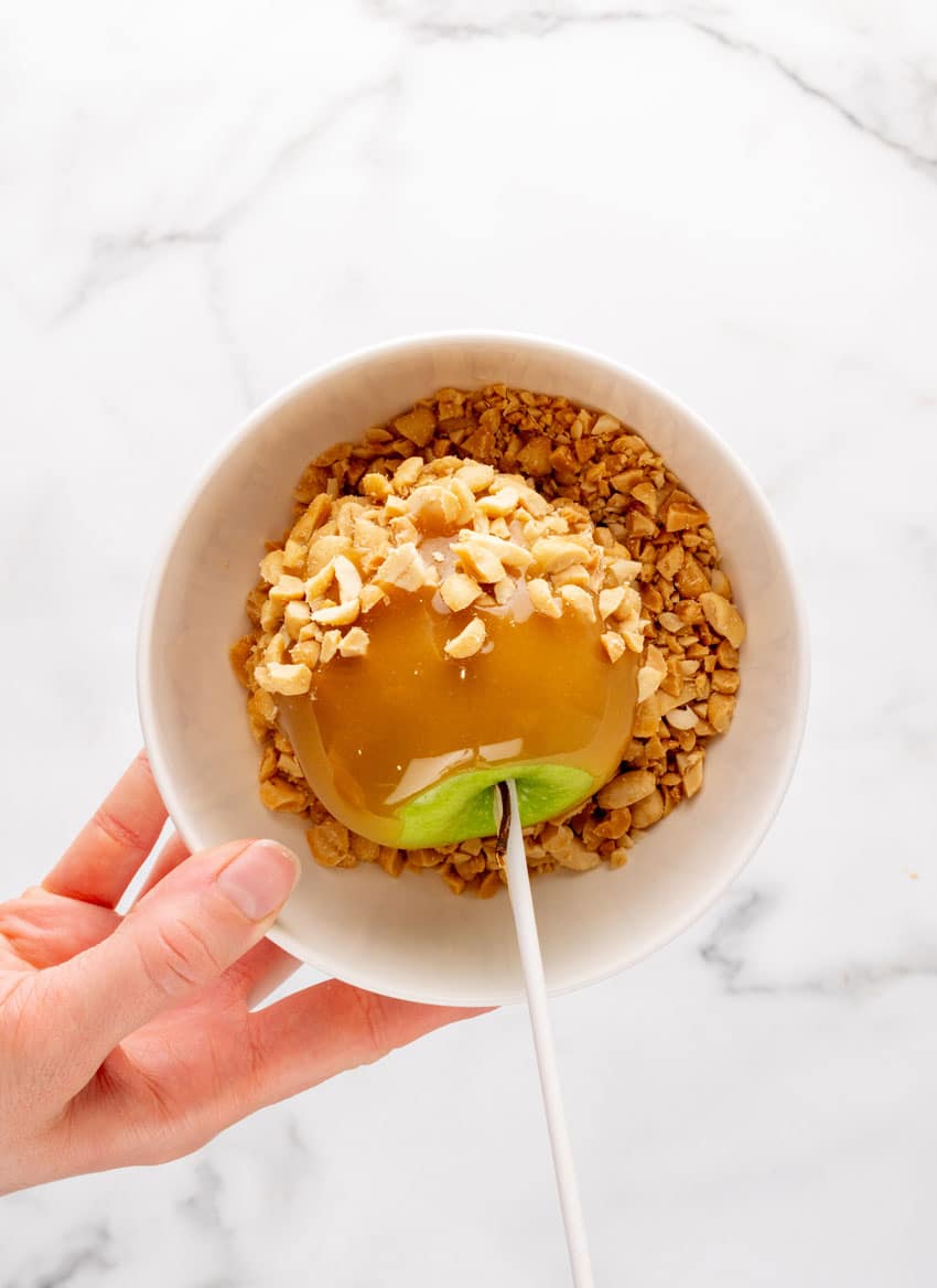 a homemade caramel apple dipped in crushed peanuts