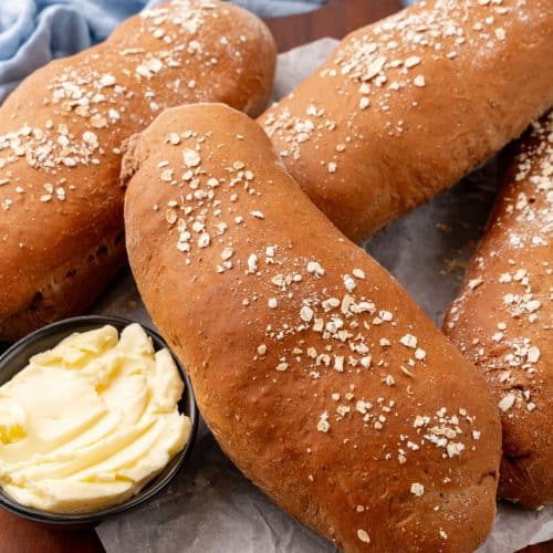 fresh loaves of copycat cheesecake factory brown bread on a wooden serving tray