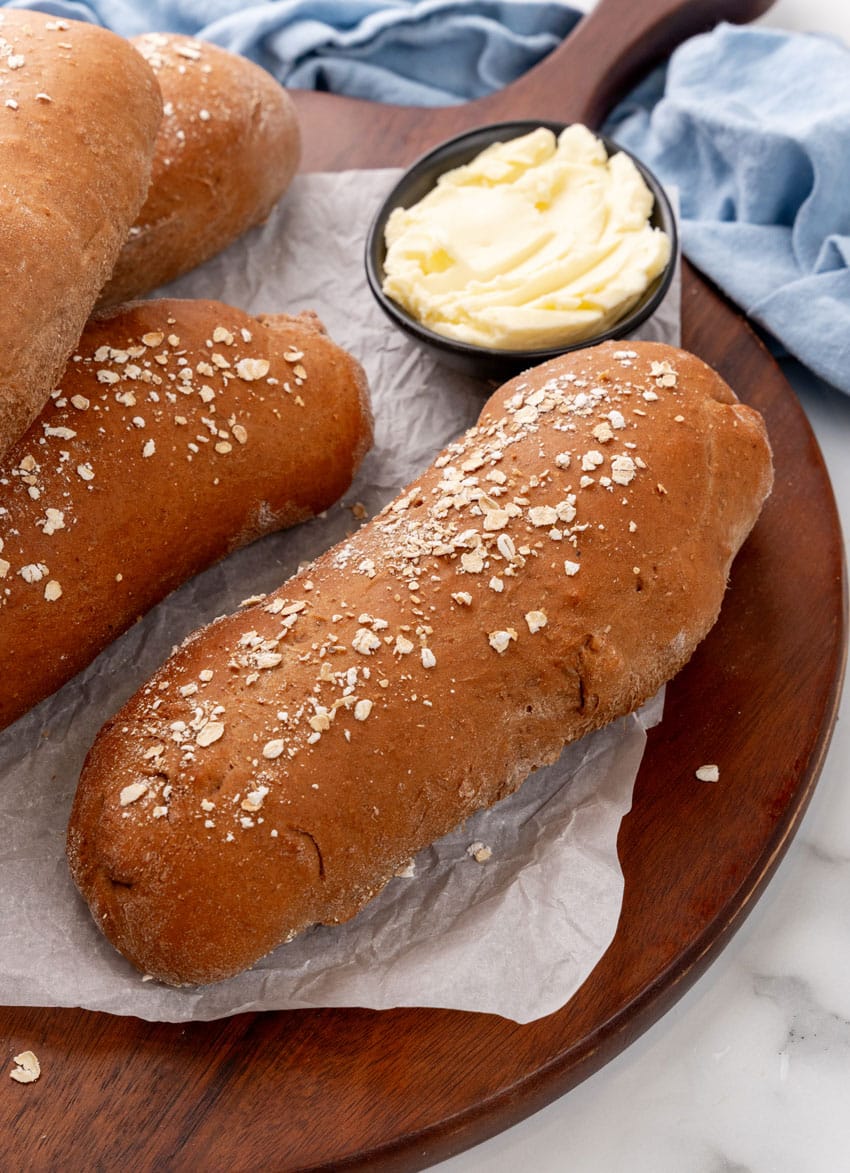 fresh loaves of copycat cheesecake factory brown bread on a wooden serving tray
