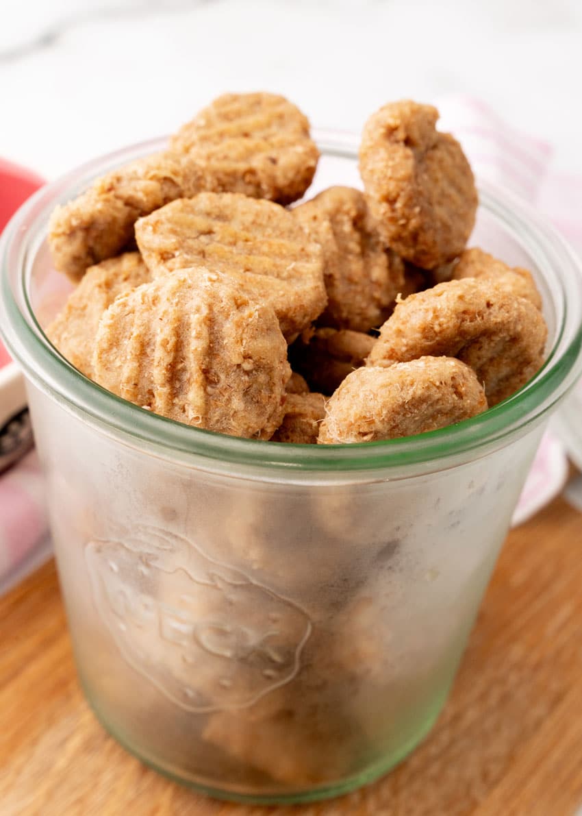 homemade cat treats in a small glass jar on a wooden serving board