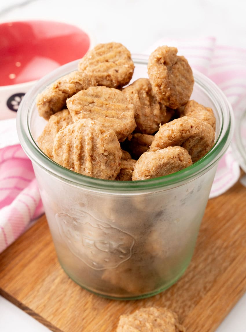 homemade cat treats in a small glass jar on a wooden serving board
