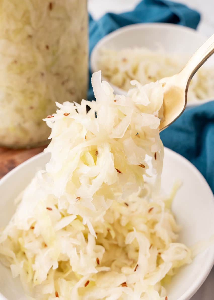 a silver fork holding up a scoop of easy homemade sauerkraut