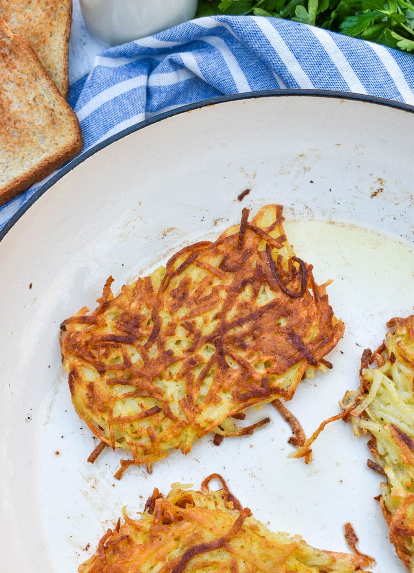 crispy fried homemade hashbrown patties in a large skillet