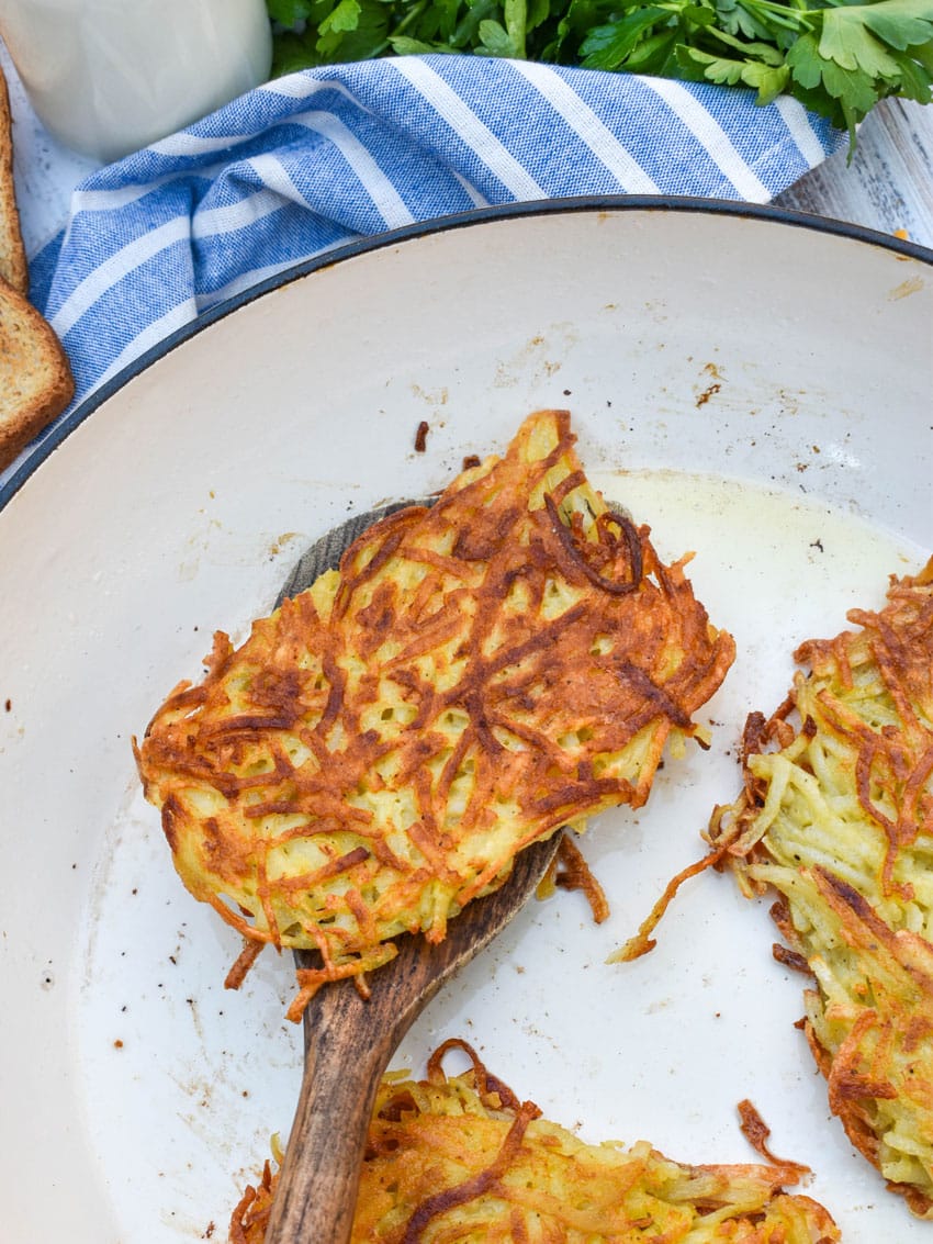 crispy fried homemade hashbrown patties in a large skillet