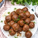 slow cooker brown sugar meatballs over a bed of steamed white rice on a small white plate
