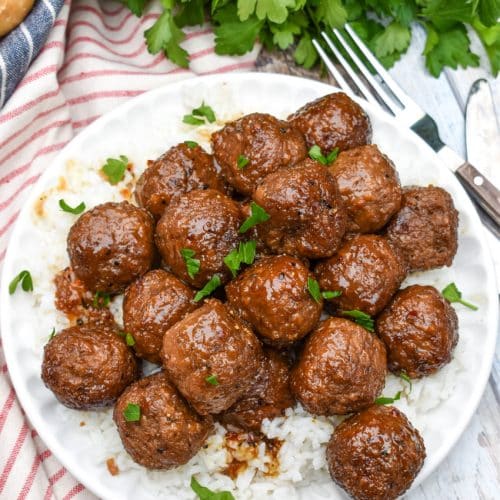 slow cooker brown sugar meatballs over a bed of steamed white rice on a small white plate