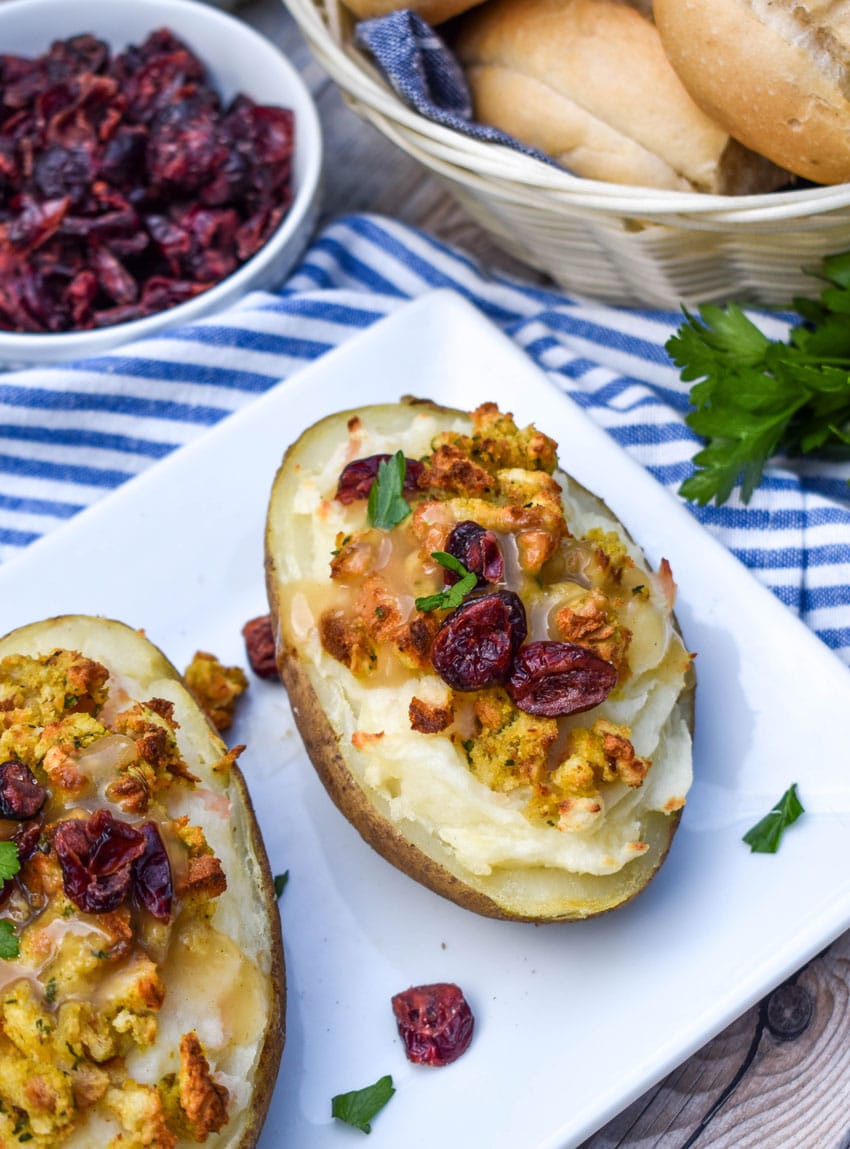thanksgiving leftover twice baked potatoes arranged in a row on a white serving platter