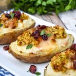 thanksgiving leftover twice baked potatoes arranged in a row on a white serving platter