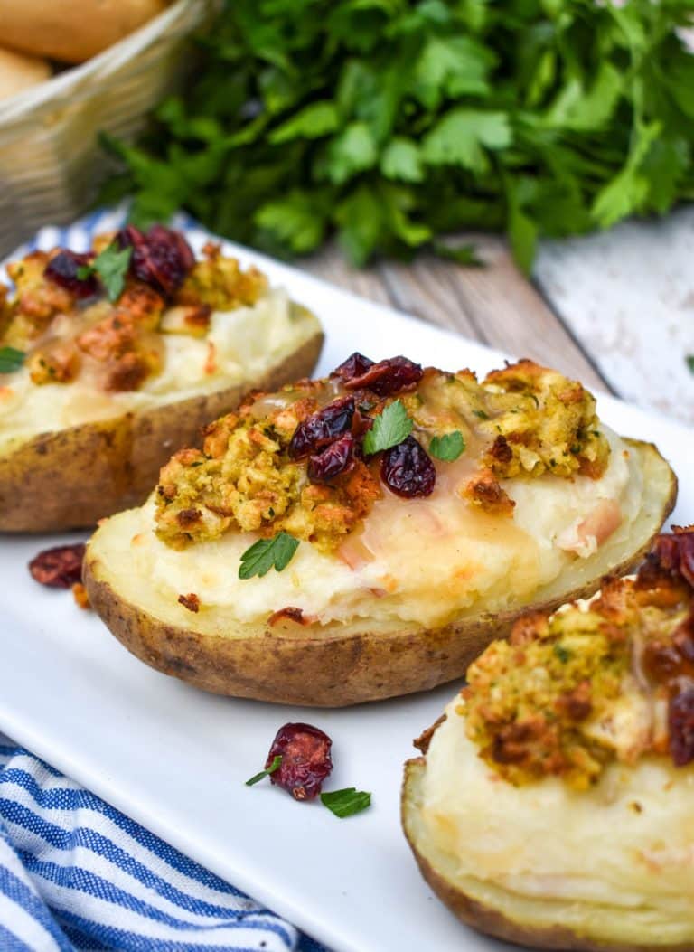 thanksgiving leftover twice baked potatoes arranged in a row on a white serving platter