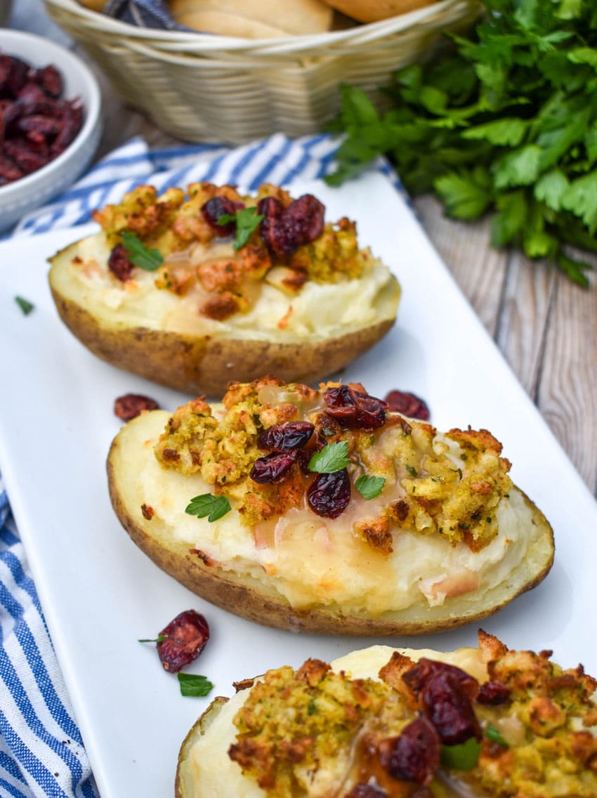 thanksgiving leftover twice baked potatoes arranged in a row on a white serving platter