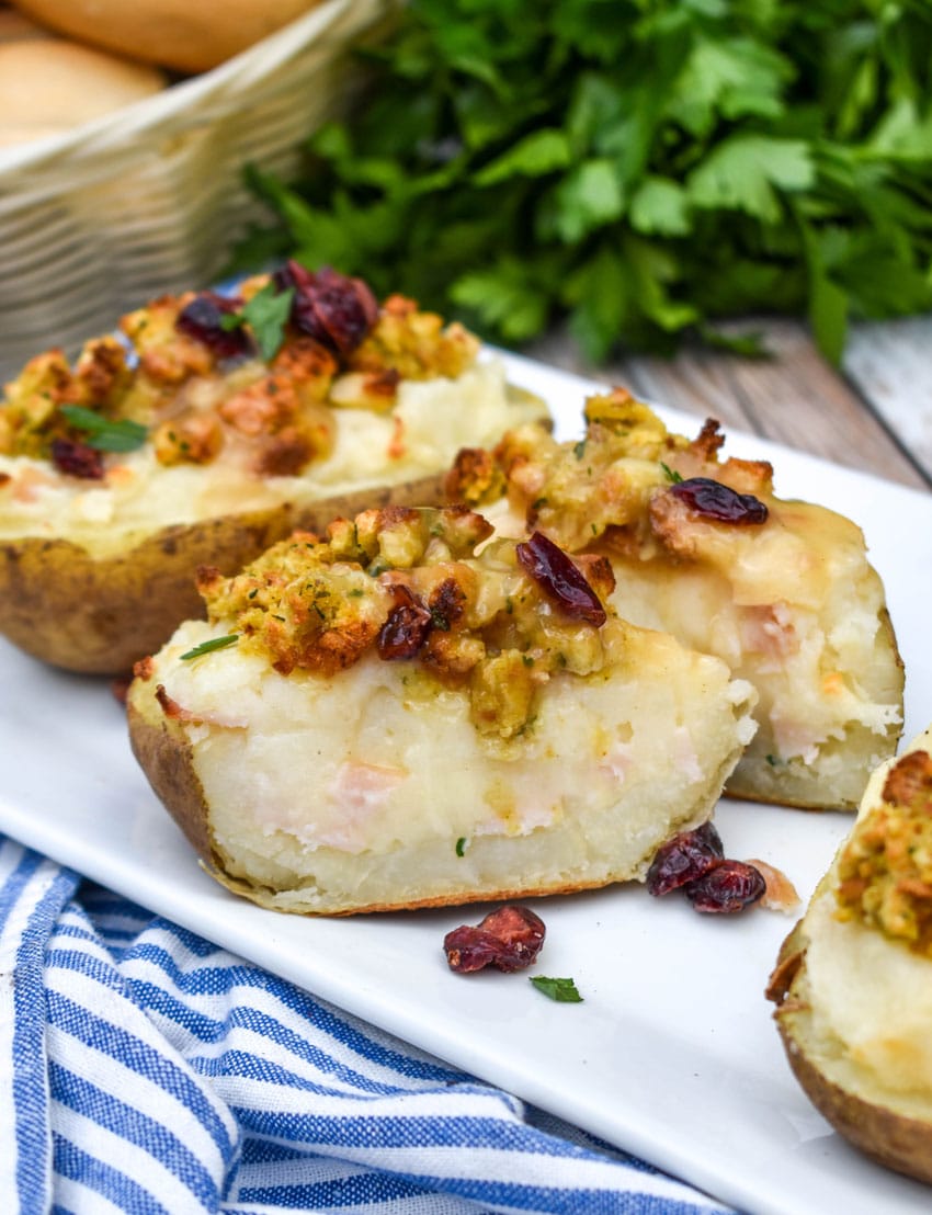 thanksgiving leftover twice baked potatoes arranged in a row on a white serving platter