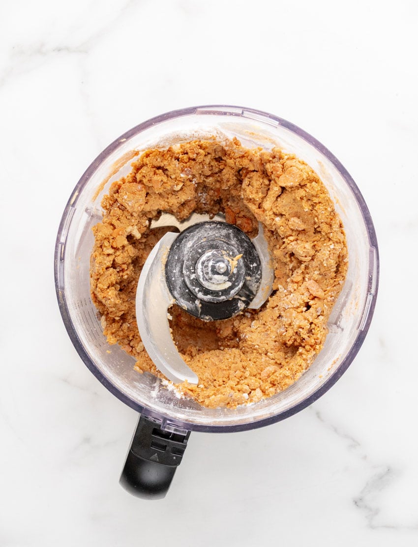 butterfinger truffle dough in the bowl of a food processor fitted with the blade attachment