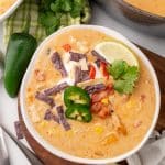 copycat chick fil a chicken soup in a small white bowl resting on a wooden serving tray