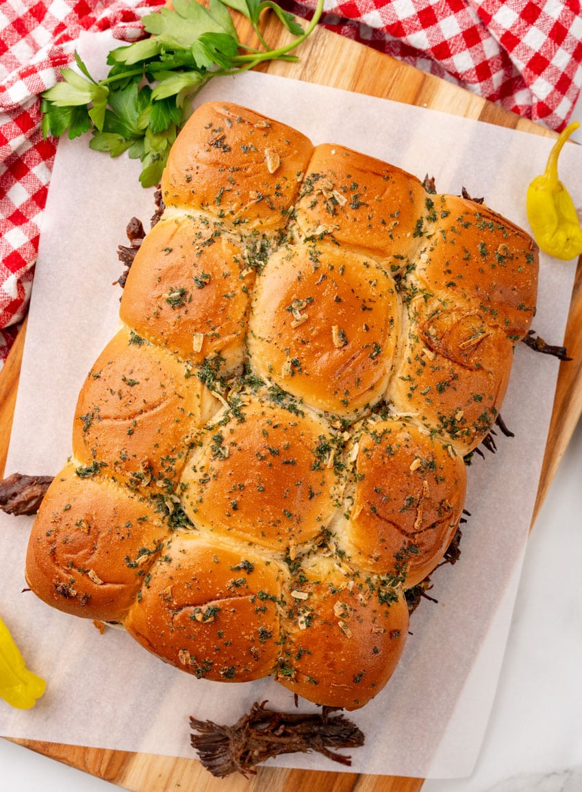 baked mississippi pot roast sliders on a parchment paper lined baking sheet