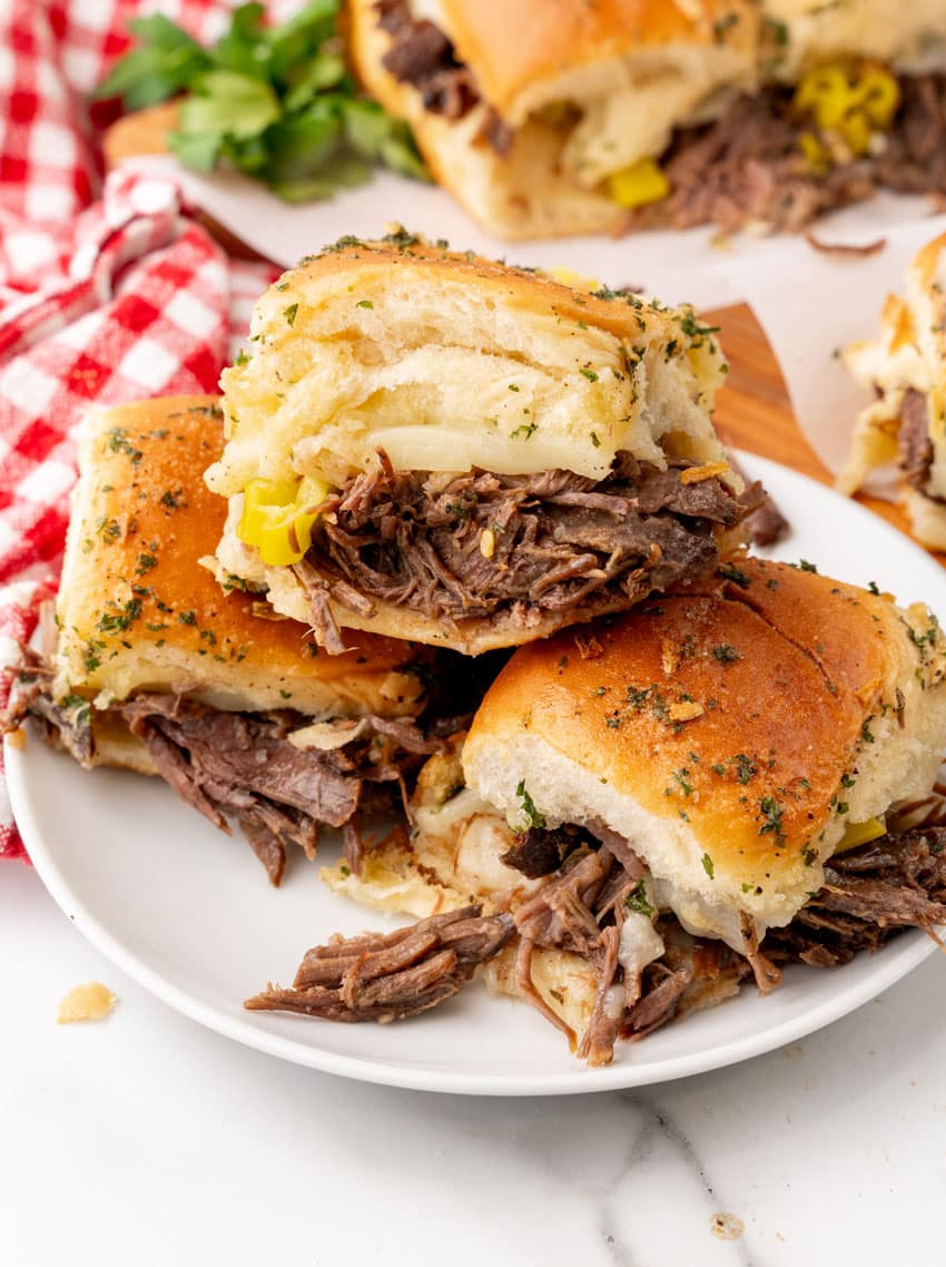 three mississippi pot roast sliders stacked on a small white plate
