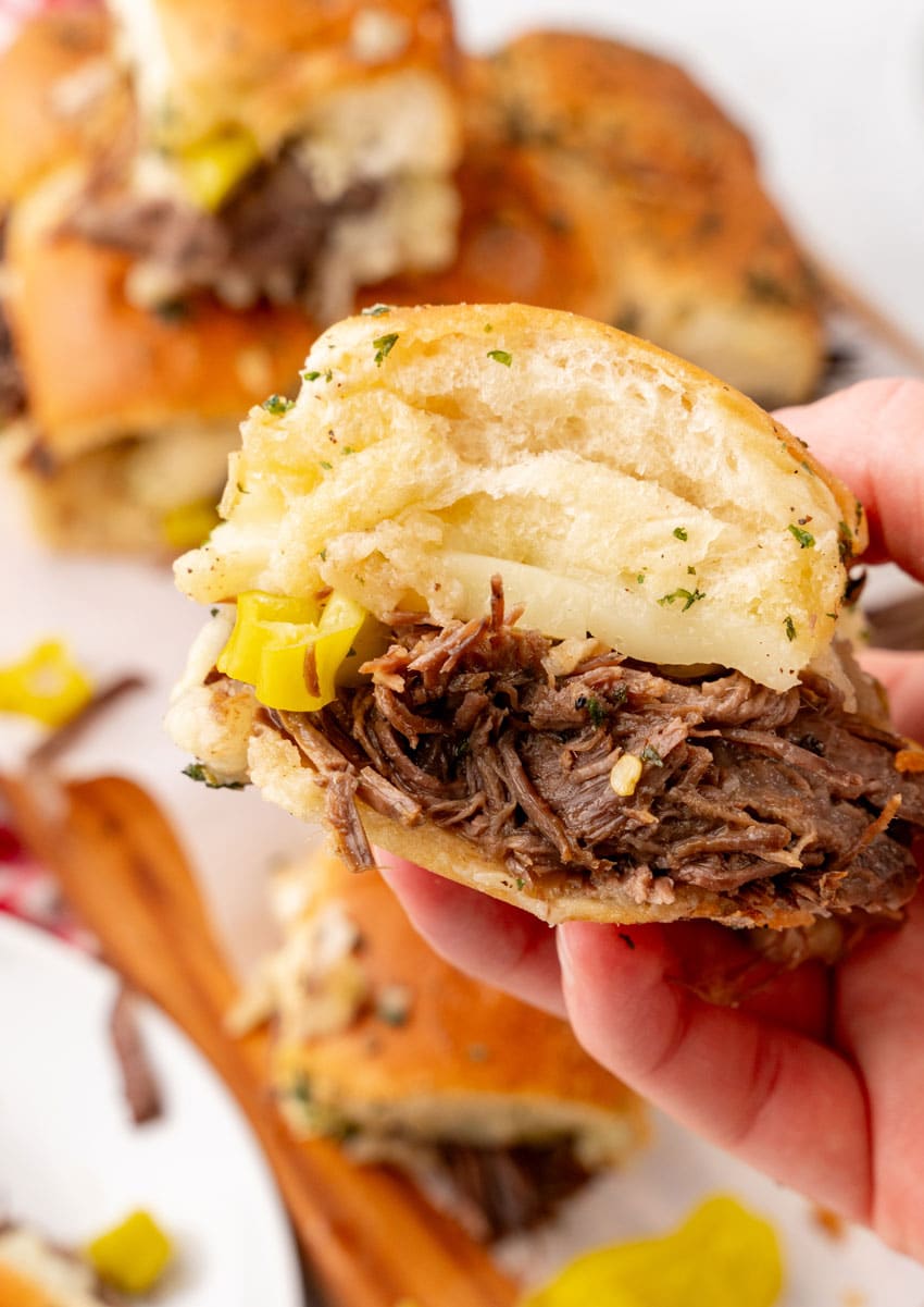 a close up of a hand holding up a mississippi beef slider