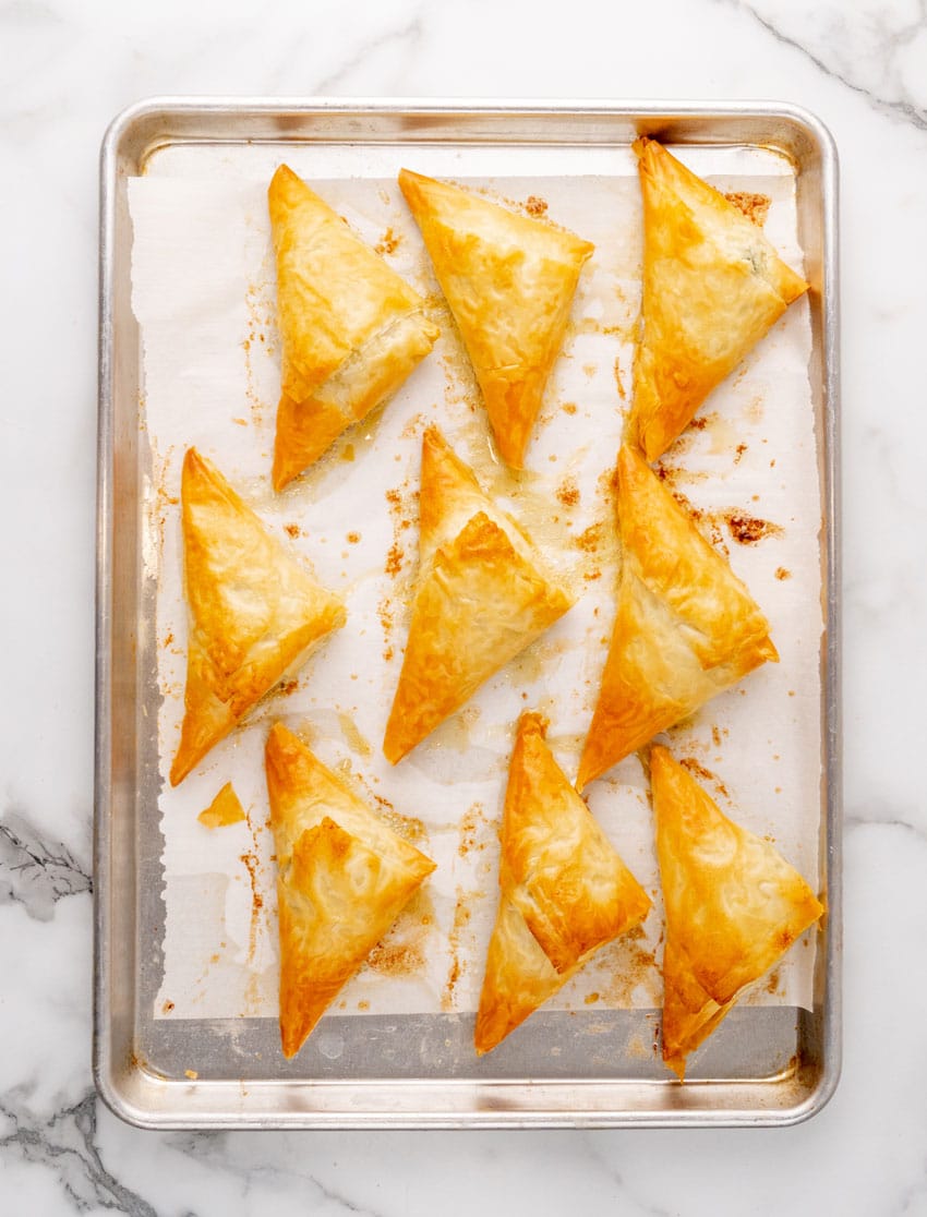 crispy baked homemade spanakopita on a parchment paper lined baking sheet
