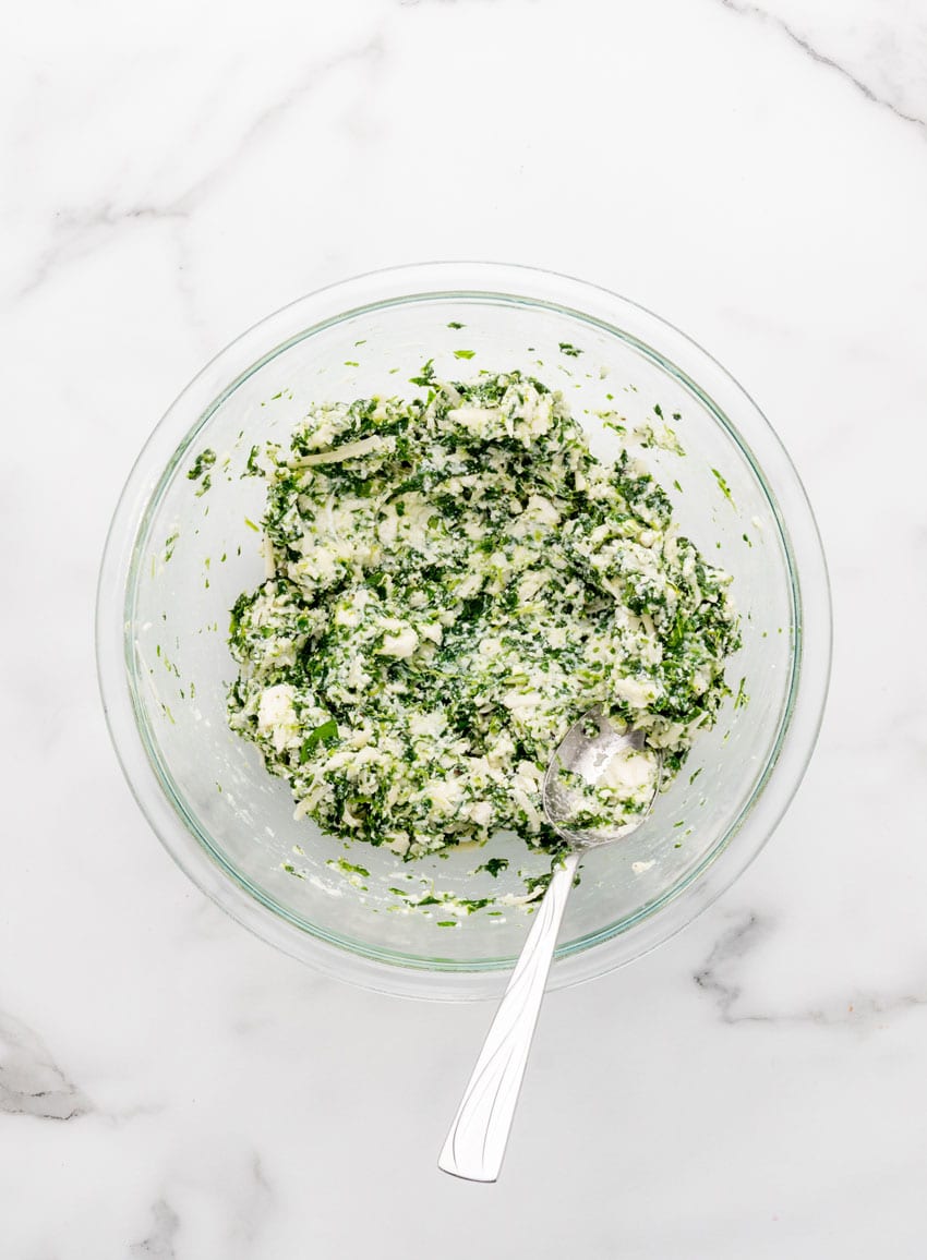 homemade spanakopita filling in a glass mixing bowl